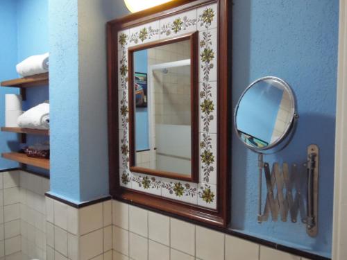 a mirror in a bathroom with a blue wall at Hostal La Lluna in Arenys de Mar