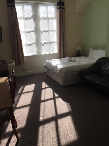 a bedroom with a bed and a large window at Gateway Lodge in Cleckheaton