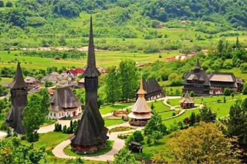 an aerial view of a village with a church at "Plai cu Peri" in Săpînţa