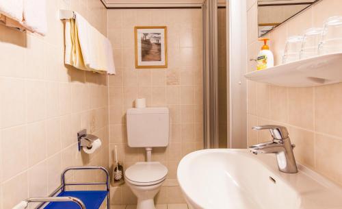 a small bathroom with a toilet and a sink at Hotel Quellental in Pinneberg