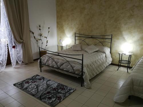 - une chambre avec un lit, deux tables et deux lampes dans l'établissement La casa di Joseph, à Catane