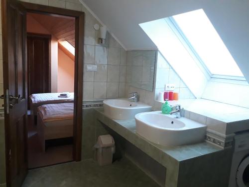 uma casa de banho com 2 lavatórios e uma janela em Penzion Fantasy - restaurant em Lipník nad Becvou