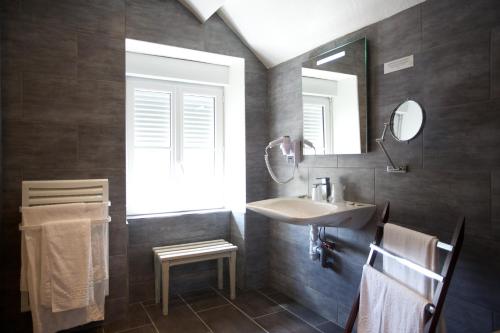 a bathroom with a sink and a mirror at logis hôtel Le petit breuil in La Courtine