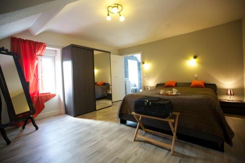 um quarto com uma cama e uma mala sobre uma mesa em logis hôtel Le petit breuil em La Courtine