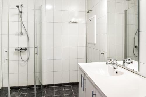 a white bathroom with a sink and a shower at Jølsterlia Hyttetun in Årdal