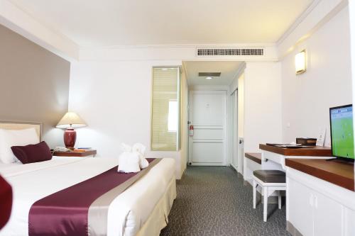 Habitación de hotel con cama y escritorio en Star Hotel Chiang Mai - SHA Extra Pus en Chiang Mai