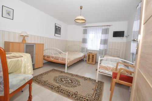 ein Schlafzimmer mit zwei Betten, einem Stuhl und einem Teppich in der Unterkunft Małgorzata 2 in Łeba