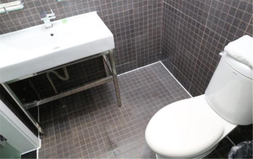 a bathroom with a white toilet and a sink at Motel Ji'nan Shandong University Shanda Road in Jinan