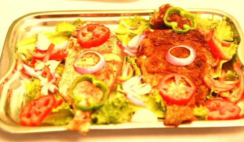 a tray of food with pizza and vegetables on it at Monarch Hotel in Accra