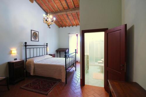 a bedroom with a bed and a door to a bathroom at Galleria di Brolio in Castroncello