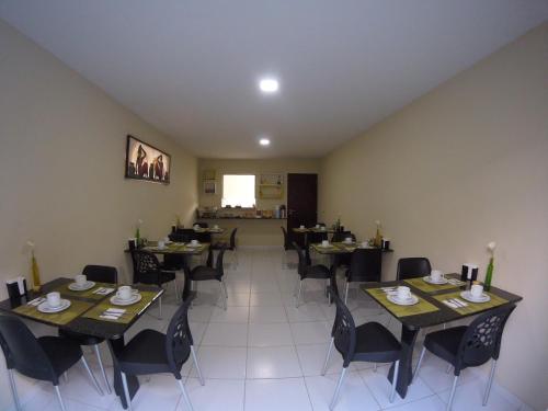 Pousada Sumaré في كاروارو: غرفة طعام مع طاولات وكراسي في مطعم