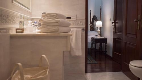 ein Badezimmer mit einem Stapel Handtücher auf der Theke in der Unterkunft Casa Robusto in Salvaterra de Magos