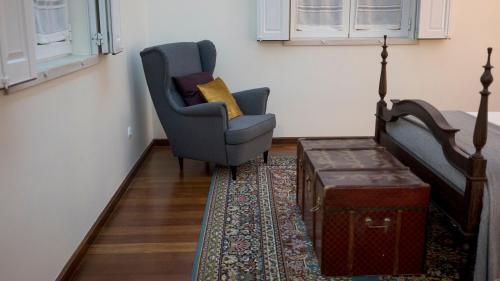 a living room with a chair and a bed and a table at Casa Robusto in Salvaterra de Magos