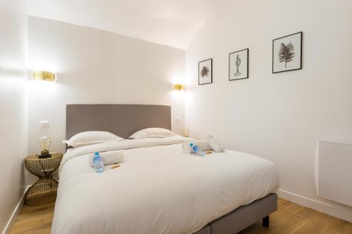- une chambre dotée d'un grand lit blanc avec deux animaux rembourrés dans l'établissement CMG Rivoli/ Notre-Dame I, à Paris