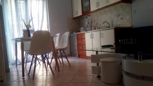 a kitchen with a table and white chairs in it at Amazing Apartment In The Center in Alexandroupoli