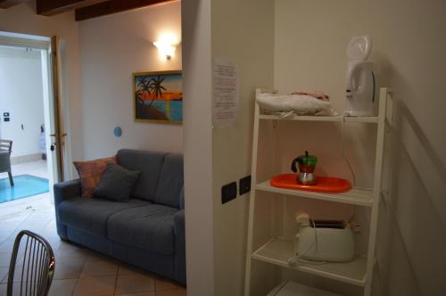 a living room with a blue couch and shelves at The Flowers Apartments 2 in Desenzano del Garda