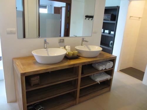 a bathroom with two sinks and a mirror at Jasmine Hills Lodge in Doi Saket