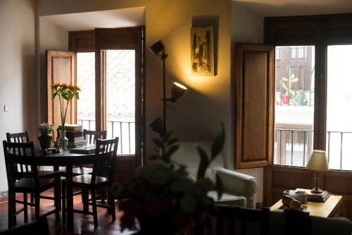 a dining room with a table and chairs and windows at Mirador del Jazmín in Granada