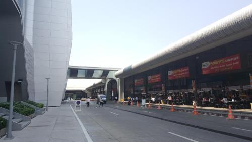 a large building with people walking down a street at Popular Condo C5 IMPACT in Pak Kret