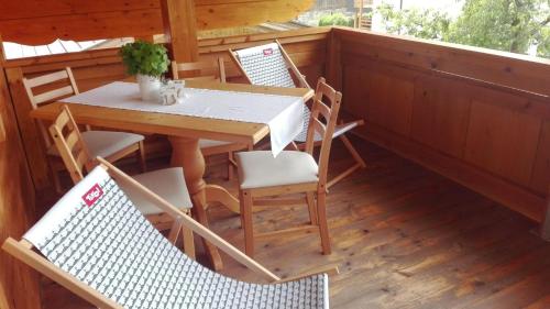 einen Tisch und Stühle auf der Veranda eines Hauses in der Unterkunft Dorfjuwel Alpbachtal in Reith im Alpbachtal