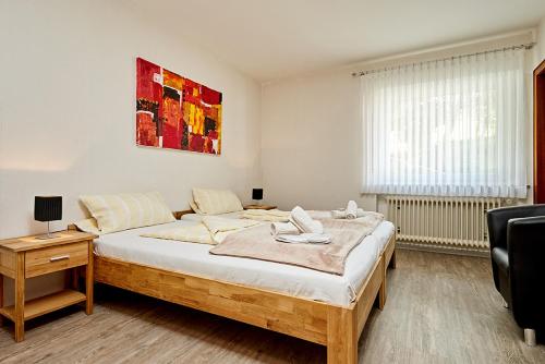 a bedroom with a bed and a table and a window at Pension Haus am Einberg in Meschede