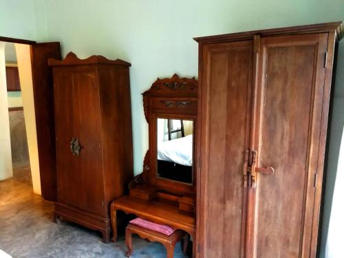 a bedroom with a wooden cabinet and a bed at Jasmine Hills Lodge in Doi Saket
