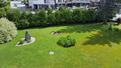 a small park with a rock in the grass at Apartments Almstein in Abtenau