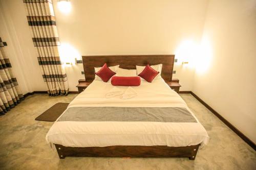 a bedroom with a large bed with red pillows at Amazing Villa in Matara