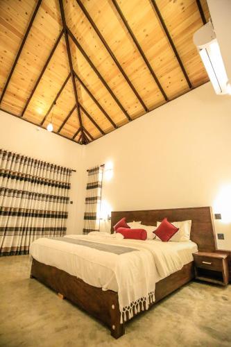 a bedroom with a large bed with red pillows at Amazing Villa in Matara
