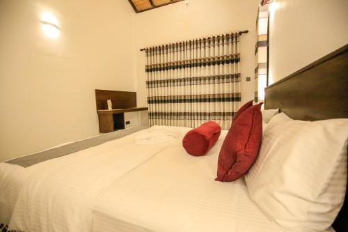 a bedroom with a bed with red pillows on it at Amazing Villa in Matara