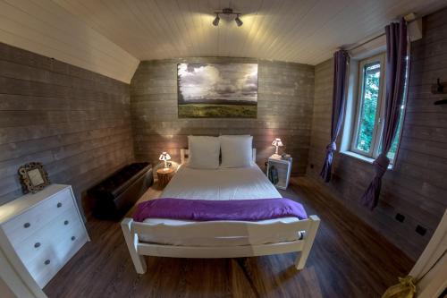 a bedroom with a bed in a small room at L'Esprit du Bois in Aydat