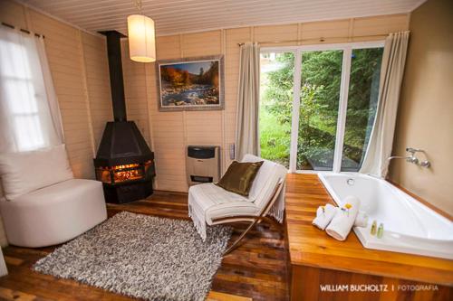 a bathroom with a bath tub and a fireplace at Pousada Pedra Preta in Urubici