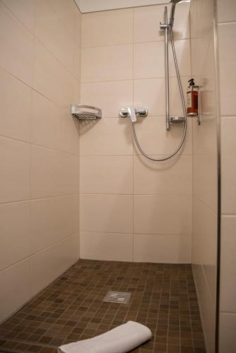 a shower in a bathroom with a tile floor at Gasthof Stocker in Landsham
