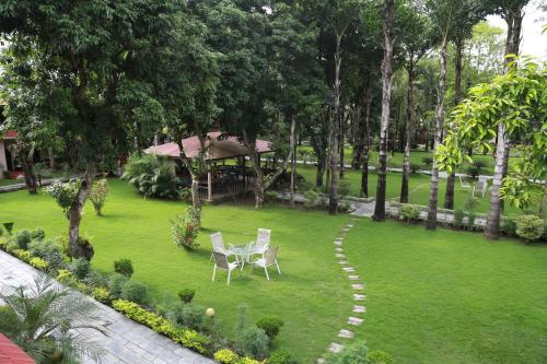 a lawn with chairs and a gazebo in a park at Hotel Parkland in Sauraha