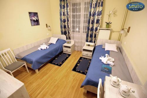 Habitación con 2 camas, mesa y sillas en Pensjonat Sanato, en Busko-Zdrój