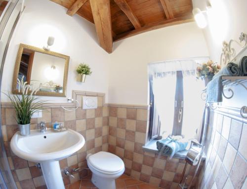bagno con lavandino, servizi igienici e specchio di Il Palazzetto sulla Francigena a Formello
