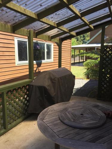 a patio with a table and a wooden pergola at Abel Tasman Marahau in Marahau