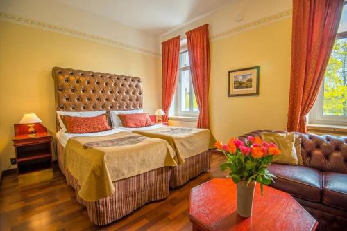 um quarto com uma cama grande e um sofá em Hotel Astor em Vaasa