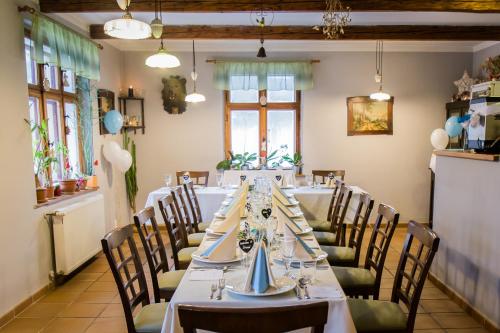 a dining room with a long table and chairs at Penzion Adršpach u Báry in Adršpach