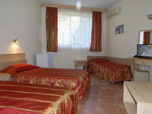 a hotel room with two beds and a television at Sirena Hotel in Kranevo