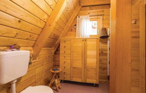 a log cabin bathroom with a toilet and a window at House with Pool and Sauna in Crni Lug