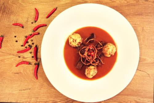 a white plate with a bowl of soup on a table at Panský mlýn in Opava