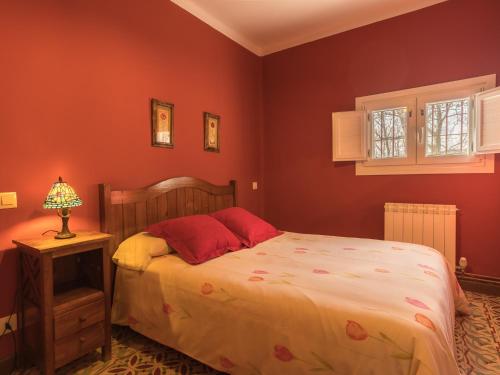 een slaapkamer met een bed met rode muren bij Los Prejones in Arenas de San Pedro
