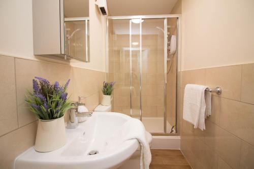 a bathroom with a white sink and a shower at DPV - Above Bar Street Apartments in Southampton