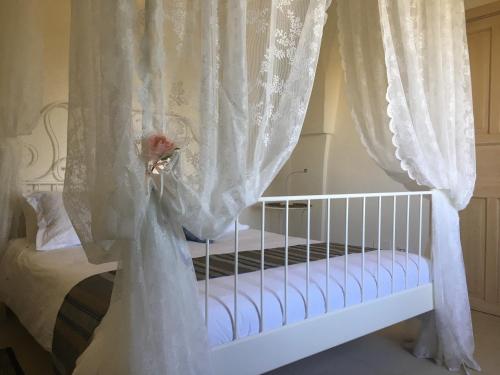 a crib with white curtains and a flower on it at Masseria San Polo in Squinzano