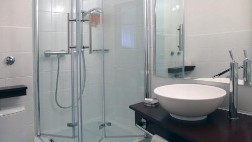 a bathroom with a sink and a glass shower at Cityhotel Amadeus in Münster