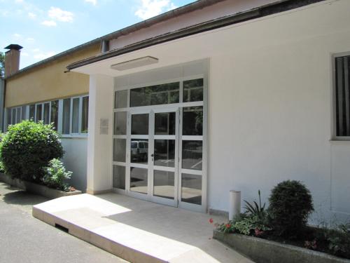 a white building with a large glass door at Boarding House Lucija in Kostrena