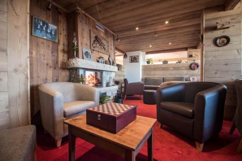 - une salle d'attente avec des chaises, une table et une cheminée dans l'établissement Le Relais du Petit Saint Bernard, à La Rosière