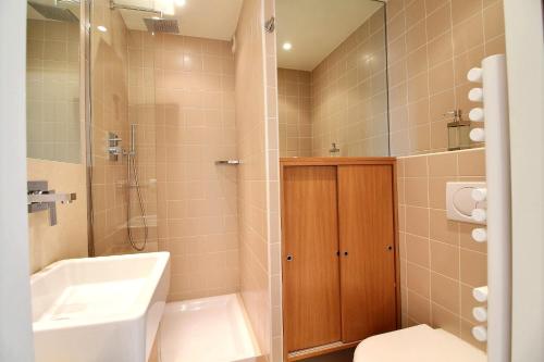 La salle de bains est pourvue d'un lavabo, de toilettes et d'une douche. dans l'établissement Le Grand Hotel, à Cannes