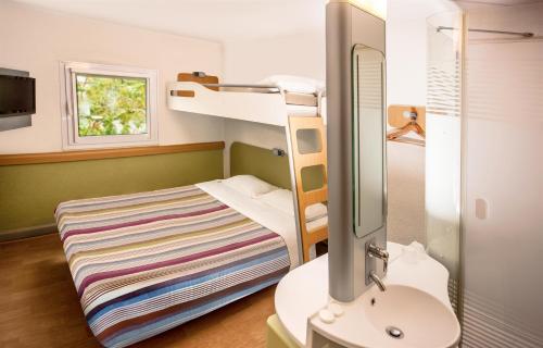 SUN1 MIDRAND في ميدراند: غرفة صغيرة مع سرير بطابقين ومغسلة